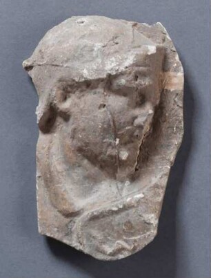 Kopf und Halsausschnitt eines behelmten Römers mit Schild (Blitzbündel) im Profil nach rechts