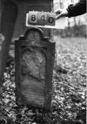 Grabstein 840 (Index: 99751437) Material: Sandstein Zustand: abgeblätt/verwitt/fast völl. Textverlust Maße HxBxT: 85x37x11 cm Beschreibung: Stele, doppelt eingezog. Rundbogenabschl. , Schrift eingetieft mit Segmentbogenabsch: Grabstein 840