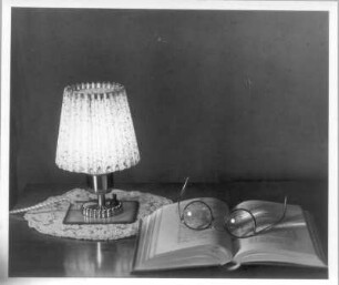 Stilleben mit Nachttischlampe, Buch und Brille