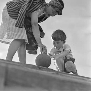 Elisabeth Gremmler und ihr Kind spielen Ball auf einer Treppe