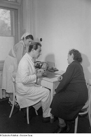 Arzt und Krankenschwester mit Patientin