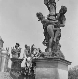 Elisabeth Gremmler sitzt zusammen mit einem befreundeten Mann auf einem Geländer neben einer Statue