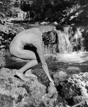 Frauenakt, an einem Gebirgsbach Wasser schöpfend