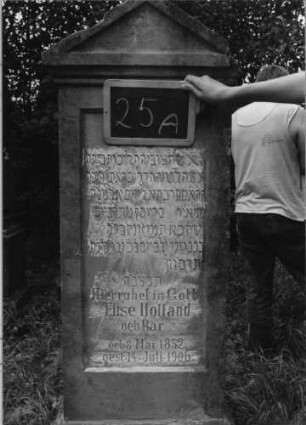 Grabstein 25 (Index: 99753458) Material: Sandstein Zustand: verwittert Maße HxBxT: 160x56x30 cm Beschreibung: Stele, getreppter Sockel, Giebel, eingetieftes Schriftfeld rechteckig: Grabstein 25A