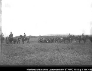 Geländeübung des Feld-Artillerie-Regiments Nr. 46 Enthält: Soldaten zu Pferd und zu Fuß, auf mit Pferden bespannten Geschützlafetten und hinter Geschützen, im Hintergrund: Erdwälle