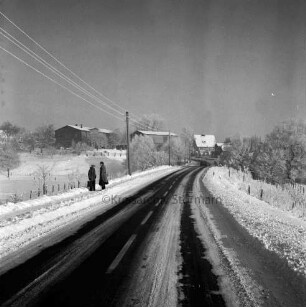 Lokfelder Heckkaten: Kreisstraße zwischen Lokfeld und Reinfeld: links zwei Frauen im Gespräch: hinten rechts Pkw: im Hintergrund Häuser: Winter