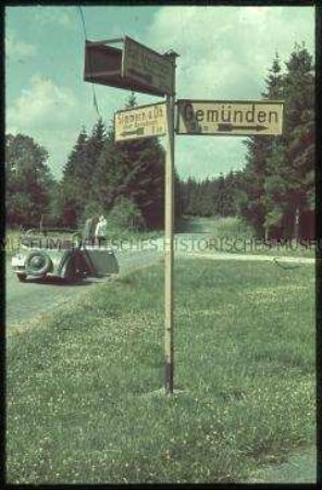 Wegweiser und Auto an einer Kreuzung im Hunsrück