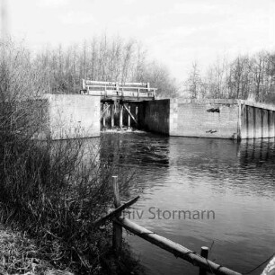 Ehlersberg: Alster: Tangstedter Schleuse (auch: Heidkruger oder Ehlersberger Schleuse): vorn Zaun an Uferböschung: links Sträucher: hinten Bäume: Winter