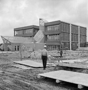 Schulzentrum Reinbek: Mühlenredder: Realschule Reinbek [später: Gemeinschaftsschule Reinbek zusammen mit Hauptschule / Hertzig-Schule]: Neubau: vorn Holzverschalungen: dazwischen Arbeiter: dahinter rechts Fundamente zwischen Sandhaufen: darauf Mann: hinten Hauptschule