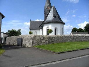 Evangelische Kirche-Ansicht von Ostsüdosten mit Kirche (Gotische Gründung 15 Jh) mit Dachturm über Kirchhofmauer (Wehrgang mit Steinbrüstung und Schießscharten abgetragen)