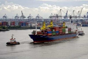 Zwei Schlepper manoevrieren auf der Elbe einen Container-Frachter in der Hamburger Hafen. Im Hintergrund die Container-Terminals Eurogate und Burchardkai