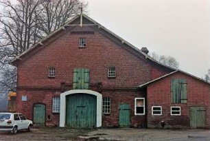 Schönningstedt: Dorfstraße 17: Bauernhaus aus Backstein: Giebelseite Wirtschaftstrakt: Scheunentor, darüber Luke, beiderseits Stalltüren, oben Giebelzier, rechts Stallanbau