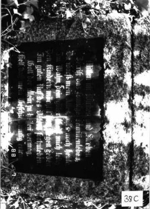 Grabstein 38 (Index: 100101207) Material: Granit, schwarze Glasplatte im Sockel Zustand: gut Maße HxBxT: 163x60x28 cm Beschreibung: Obelisk, Sockel, Schriftplatten Symbolik: Voluten: Grabstein 38C