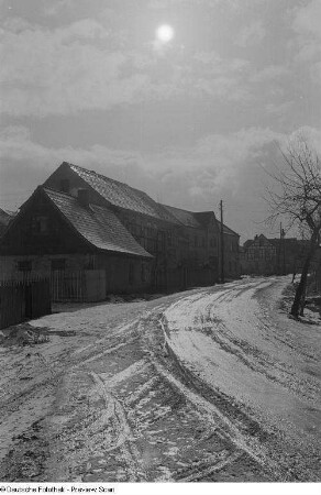 Wohnhäuser an einer verschneiten Dorfstraße
