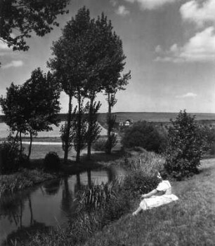 Junges Mädchen, am Ufer eines Flusses sitzend