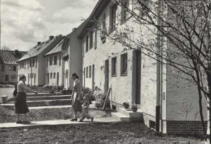 Wohnsiedlung : Reihenhäuser in neugebauter Wohnsiedlung im Vordergund die Bewohner
