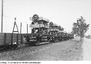Güterzug einer Schmalspurbahn mit Rollwagen, darauf Flachwagen mit z. T. doppelt übereinandergestellten LKW-Anhängern, Juli 1956 - Februar 1957