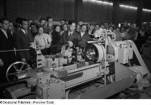 Besucher des chinesischen Pavillons der Leipziger Herbstmesse 1954 betrachten die Vorführung einer Industriemaschine