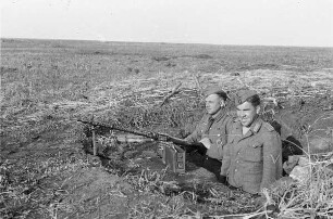 Zweiter Weltkrieg. Frontbilder. Sowjetunion. Angehörige der deutschen Wehrmacht in einem Schützenloch an einem Maschinengewehr