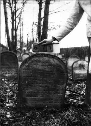 Grabstein 571 (Index: 100115336) Material: Sandstein Zustand: verwittert Maße HxBxT: 78x59x10 cm Beschreibung: Stele mit Rundbogenabschluß, eingetieftes Schriftfeld: Grabstein 571