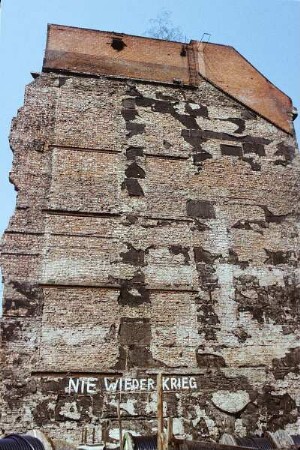 DDR. Brandmauer in einer Abrißlücke mit Graffiti "Nie wieder Krieg"
