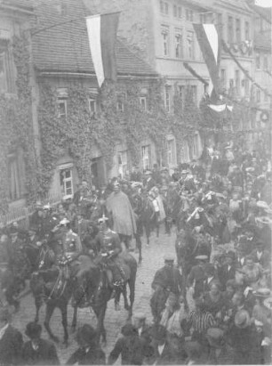 Militär mit Pickelhelm beim Ritt durch eine Stadt