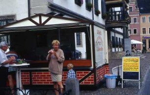 In Lutherstadt Wittenberg essen Leute Thüringer Rostbratwurst vor dem historischen Rathaus. August 2002.