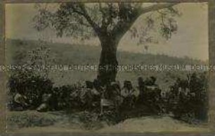 Gruppe afrikanischer Träger bei der Rast unter einem Baum