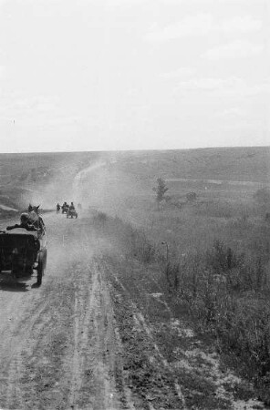 Zweiter Weltkrieg. Frontbilder. Ukraine. Unbefestigte Landstraße mit Pferdefuhrwerken der deutschen Wehrmacht