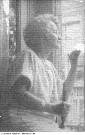Die Bildhauerin Etha Richter an einem Fenster sitzend und rauchend