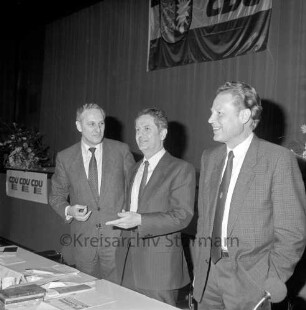 CDU: Kreisparteitag: in Bad Oldesloe: Festhalle der Dietrich-Buxtehude-Schule [Realschule], Grabauer Straße: stehend am Präsidiumstisch CDU-Kreisvorsitzender Michael von Schmude, Ministerpräsident Uwe Barschel, Landesminister für Inneres Karl Eduard Claussen: dahinter Bühne, CDU-Plakate, CDU-Fahne, Blumenschmuck, 28. März 1987