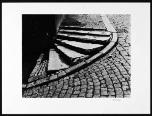 Prag. Kopfsteinplaster mit Treppenaufgang um eine Hausecke herum