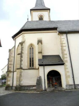 Kirche von Norden über Chor (Maßwerkfenster sowie Strebepfeiler) sowie Kirchturm (südständig hinter Chor)
