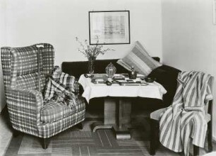 Sitzecke in einem Zimmer mit Rauchertisch und Sessel