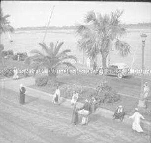 Passanten und Händler auf einer Uferpromenade am Nil, Luxor, Ägypten