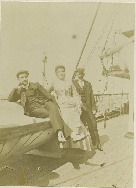 Two men and a woman on the deck of a ship