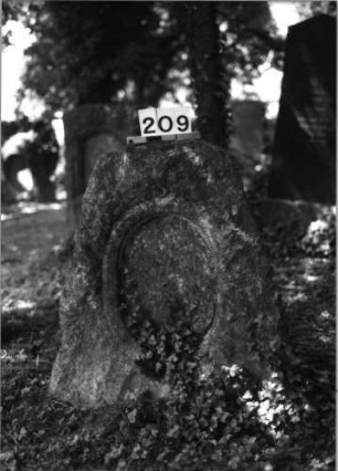 Grabstein 209 (Index: 100085304) Zustand: Schriftplatte entfernt Maße HxBxT: 95x78x40 cm Beschreibung: grob stelenhaft behauener Stein, Schriftplatte, oval: Grabstein 209