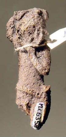 Geflügelte männliche jugendliche Figur (Eros?), sich einen Helm aufsetzend, um die Hüften ein Band (Wehrgehänge?); Beine und Flügel abgebrochen; rohe Arbeit