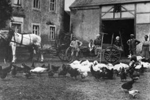 Wilsdruff-Herzogswalde. Dorfmühle, Hof mit (v. r. n. links): Martha Träbert, Schwägerin Helene, Albin Träbert, Alexander Träbert als Kind auf dem Wagen, um 1918, Repro