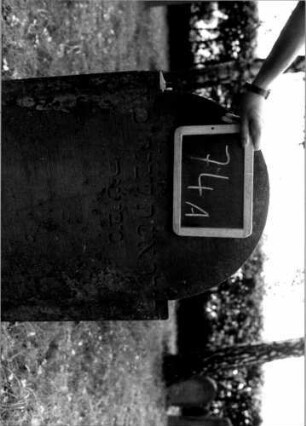 Grabstein 74 (Index: 100111154) Material: Sandstein Zustand: leicht verwittert Maße HxBxT: 110x60x12 cm Beschreibung: Stele, eingezogener Rundbogenabschluß, Schriftfeld eingetieft: Grabstein 74A