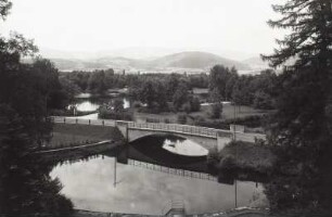 Straßenbrücke über einen Stauweiher, Blick von erhöhtem Standpunkt über die Teichdamm-Promenade gegen Riesengebirge. Blick von der ehemaligen Fullner-Villa