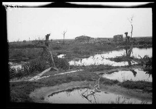 Vermutlich Zandvoorde (Belgien): Gebäuderuine, im Vordergrund breite Wasserlachen (Distanzaufnahme) ("Reste einer Ortschaft")