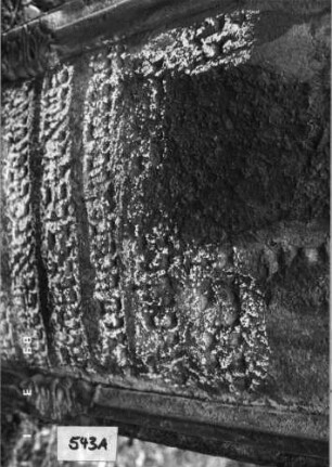 Grabstein 543 (Index: 99753000) Material: Sandstein Zustand: stark abgeblätt/verwitt. mit groß. Textver Maße HxBxT: 123x67x14 cm Beschreibung: Stele, in Voluten auslaufender Rundbogenabschluß, Schriftfeld eingetieft Symbolik: Muschel, Voluten: Grabstein 543A