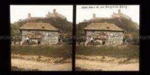 Kinder vor einem Bauernhaus im Hintergrund Burgruine Bösig