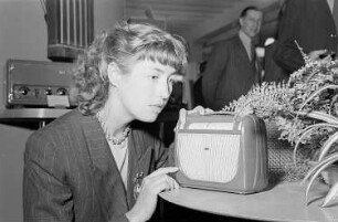 Leipziger Herbstmesse 1951 : Messebesucherin mit einem Kofferradio
