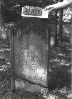 Grabstein 331 (Index: 99609968) Material: Sandstein Zustand: stark verwittert, abgebrochen, teilweiser Textverlust Maße HxBxT: 106x54x14 cm Beschreibung: Stele, eingezogener Segmentbogenabschluß, Schriftfeld eingetieft, im Bogen Feston: Grabstein 331
