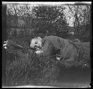 Fresnes-les-Montauban (Dep. Pas-de-Calais, Frankreich): Oberleutnant Manneberg im Gras ruhend (Nahaufnahme)