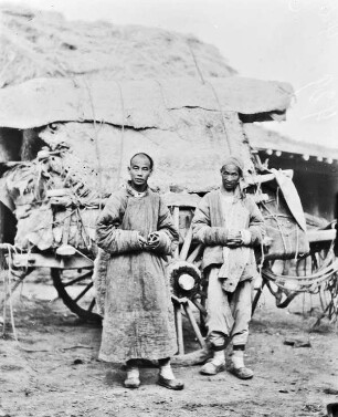 Doppelportrait : Portrait zweier Männer aus Zentralasien vor einem Pferdewagen im Tian Shan Hochgebirge