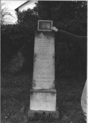 Grabstein 64 (Index: 100112235) Material: weißer Marmor, unterer Sockelteil Kalkstein Zustand: gut Maße HxBxT: 176x38x28 cm Beschreibung: Obelisk, getreppter Sockel, unterer Sockelteil rusticaartig Besonderheit: kulturhistorisch wertvoll / hist.-wiss. Gründe: Grabstein 64
