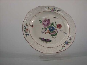 Flacher Teller mit geschweiftem Reliefrand und Blumenmalerei